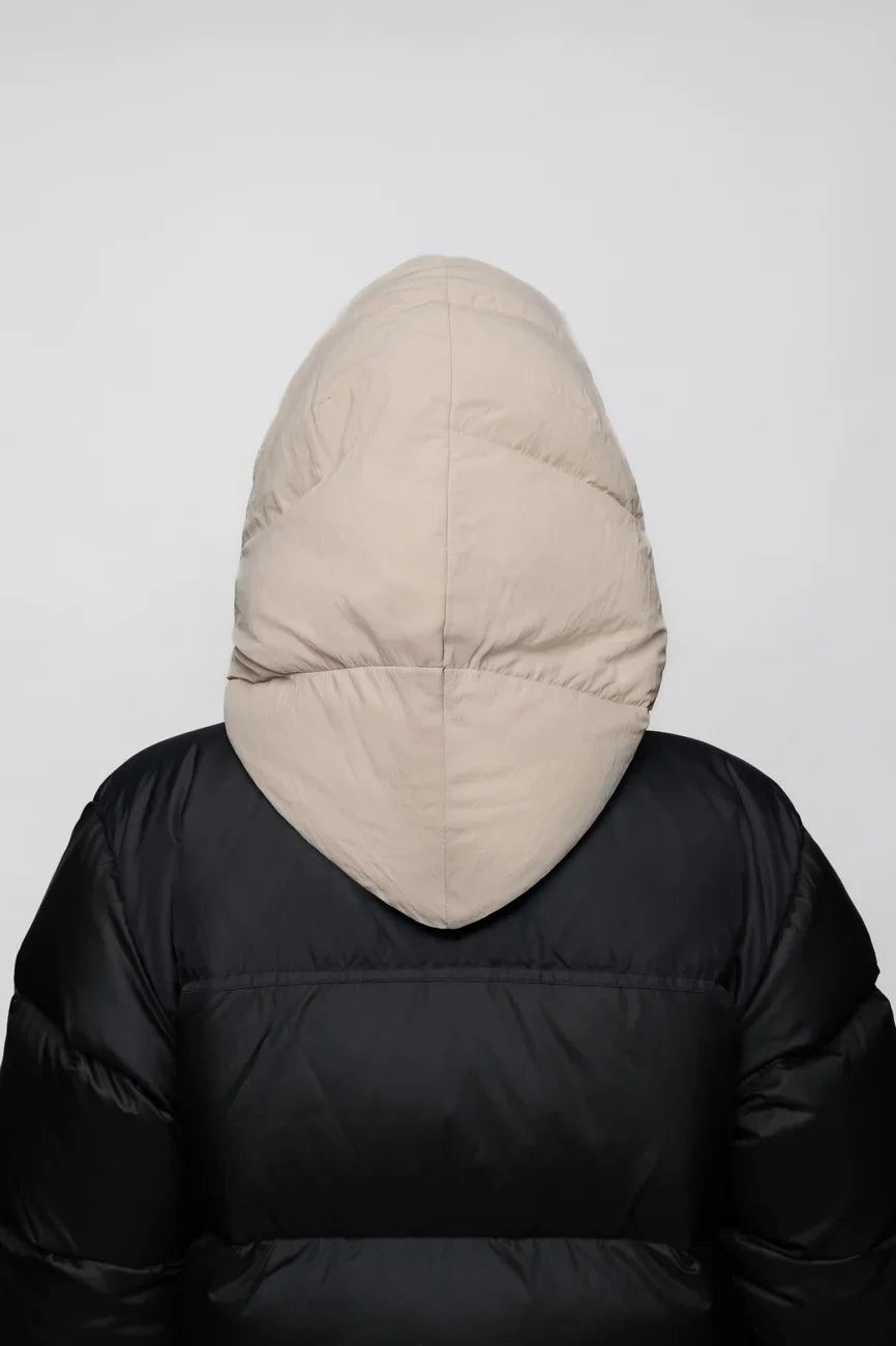 Light beige vegan winter capuche made from recycled materials, shown from the back on a black puffer jacket. - The New Orchard - Light Beige