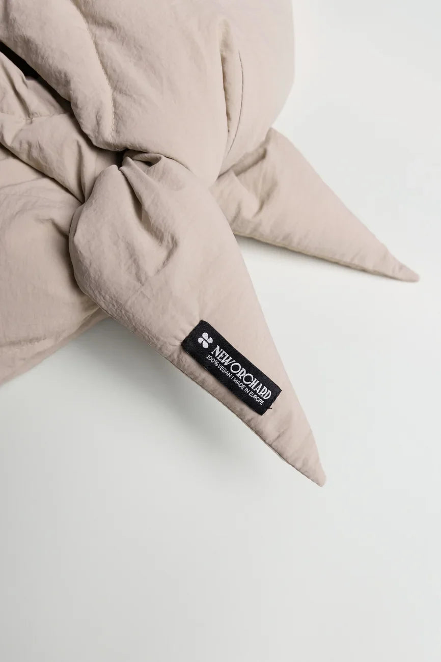 Light beige vegan capuche with pointed ends made from recycled materials, featuring a black label. - The New Orchard - Light Beige