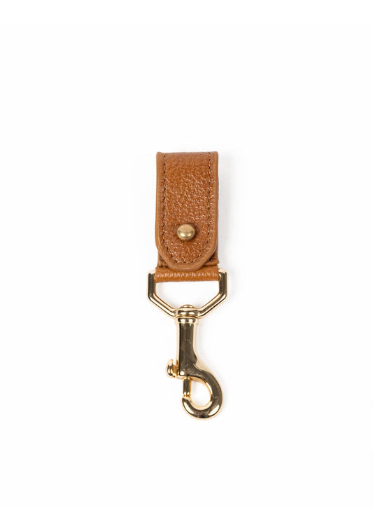 Cognac leather key chain with gold clasp on a white background