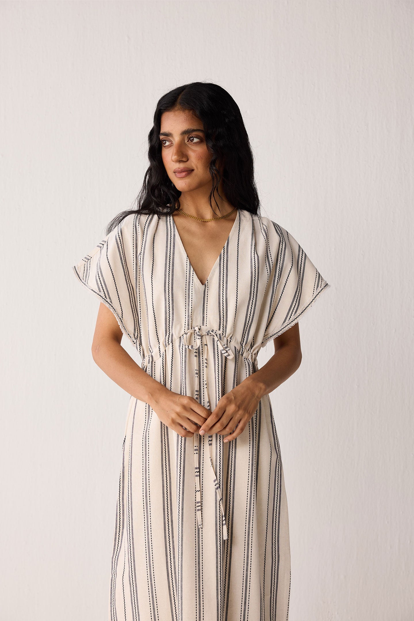 Woman wearing a striped dress against a plain background