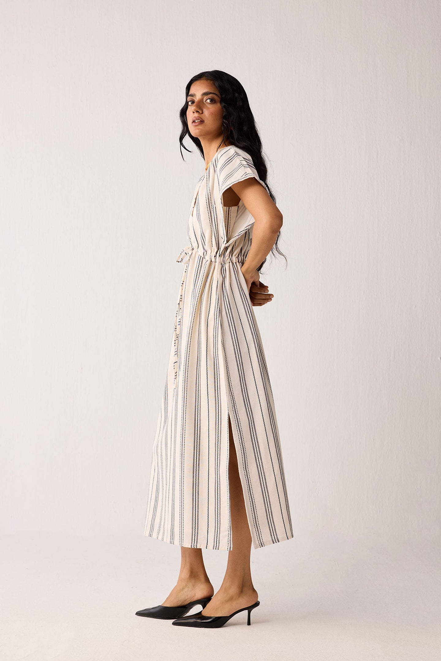 Woman wearing a striped dress on a plain background