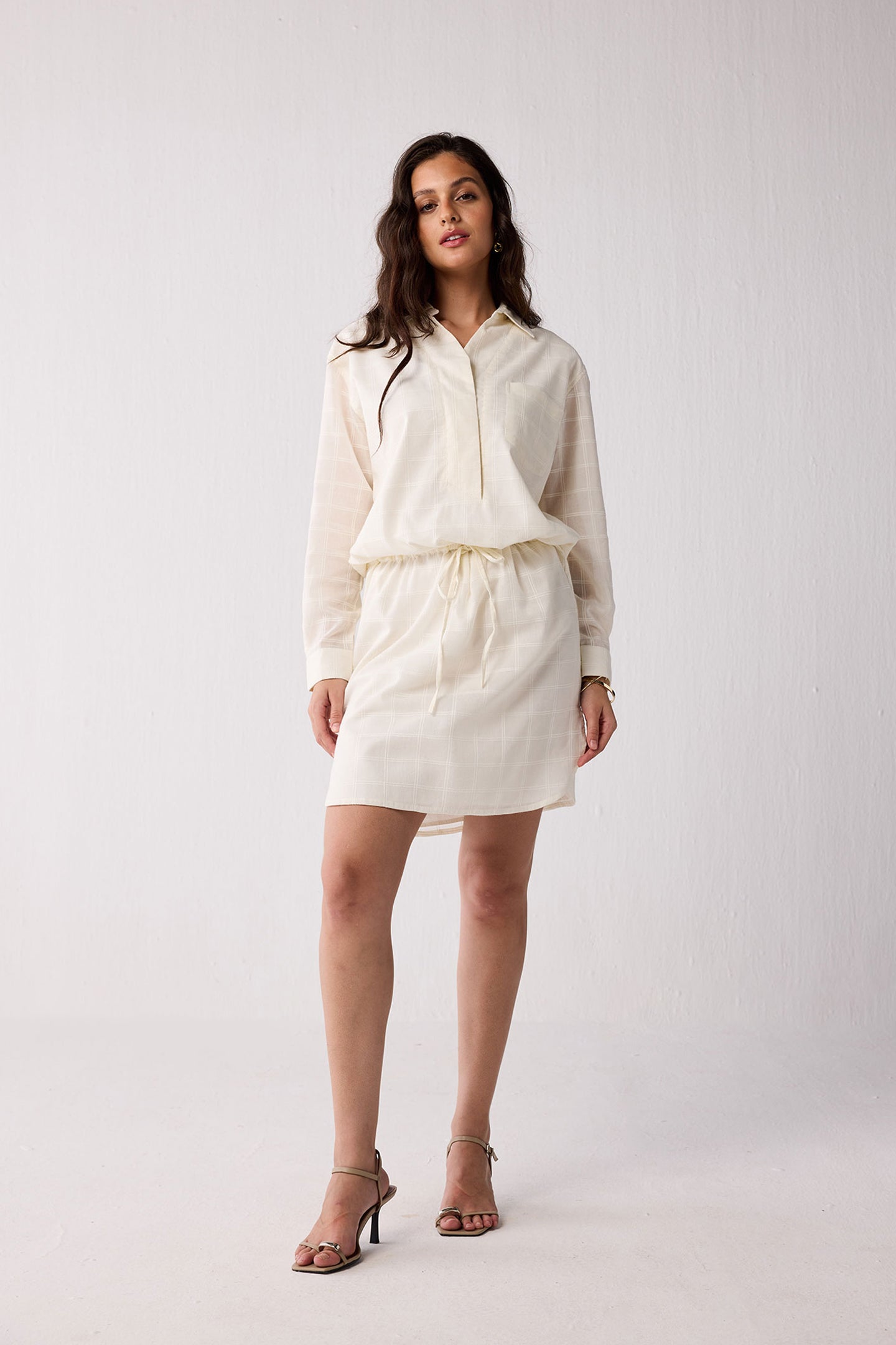 Woman wearing a white outfit on a plain background