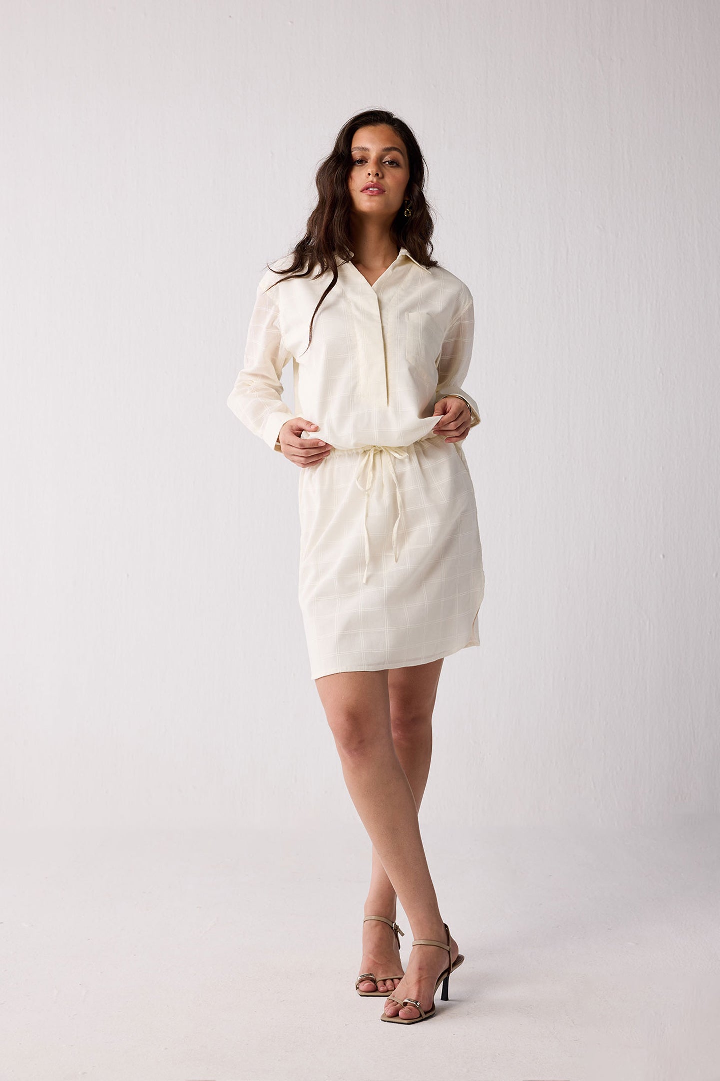 Woman wearing a white dress against a plain background