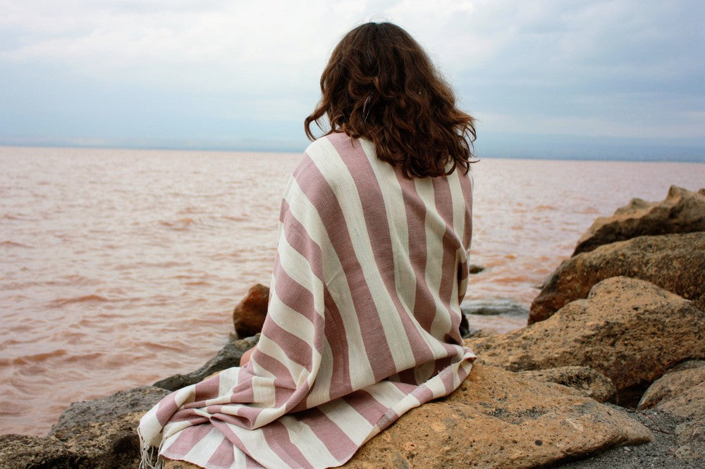 Omo beach towel wrapped around female model at the. beach  