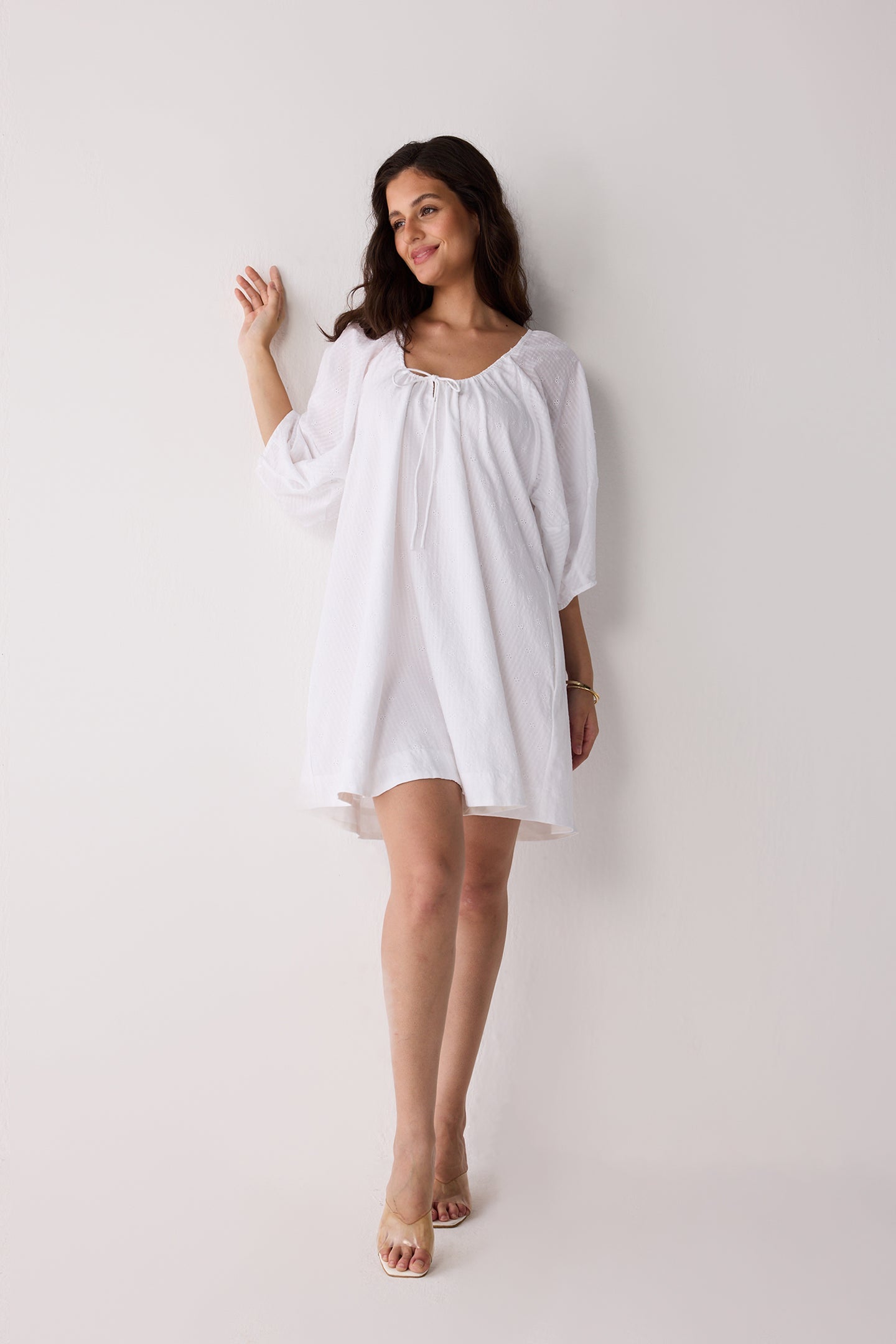 Woman wearing a white dress against a plain background