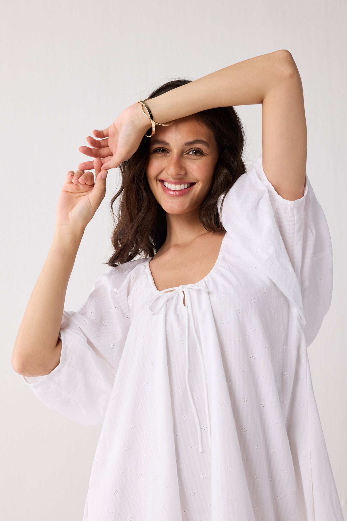 Woman wearing a white dress against a plain background