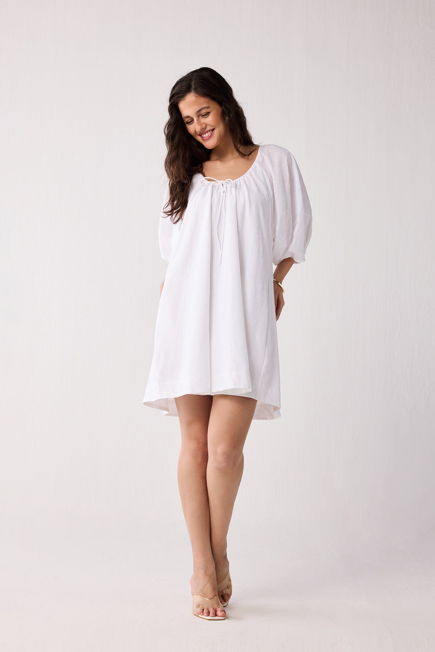 Woman wearing a white dress against a plain background