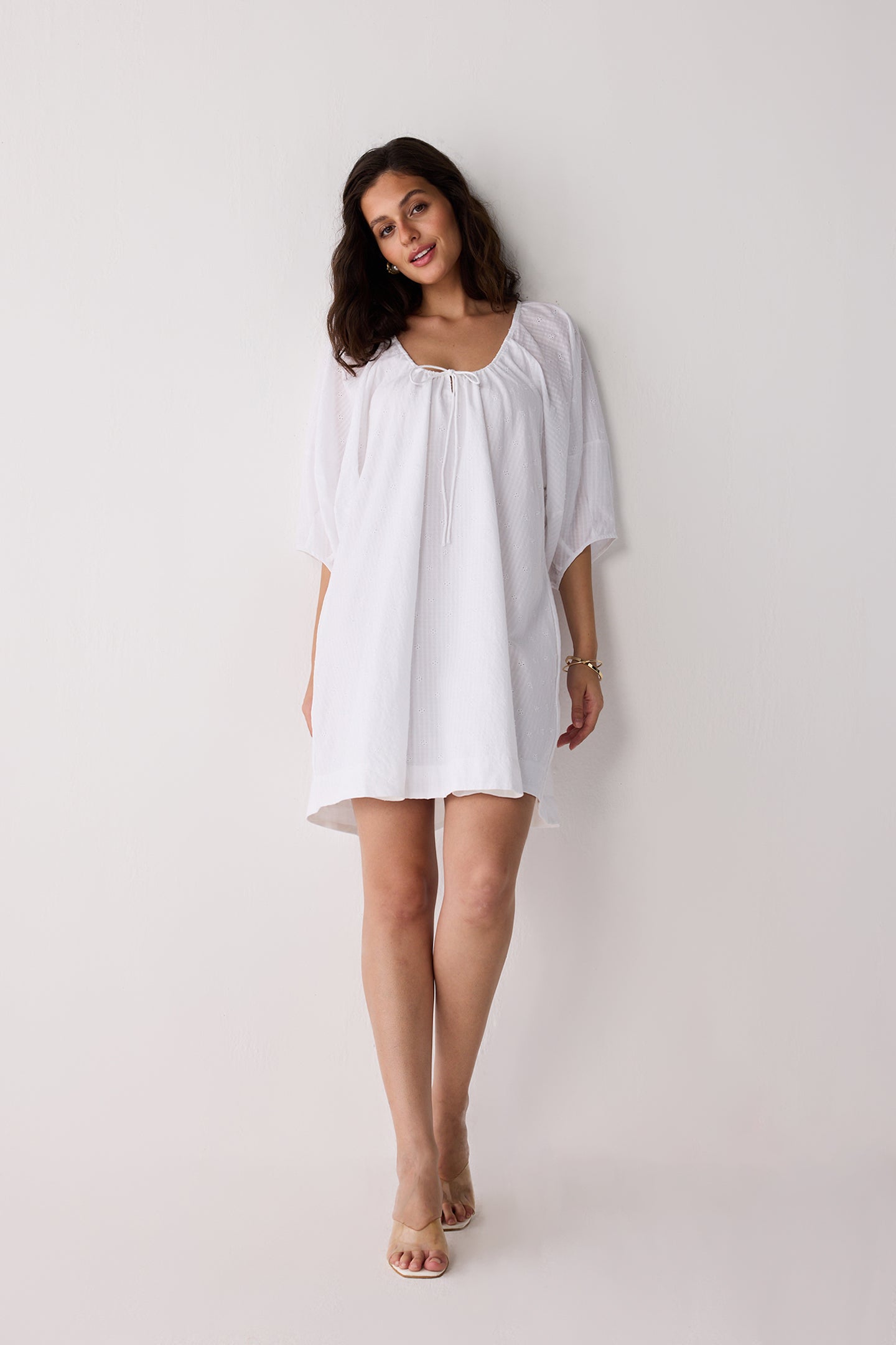 Woman wearing a white dress against a plain background