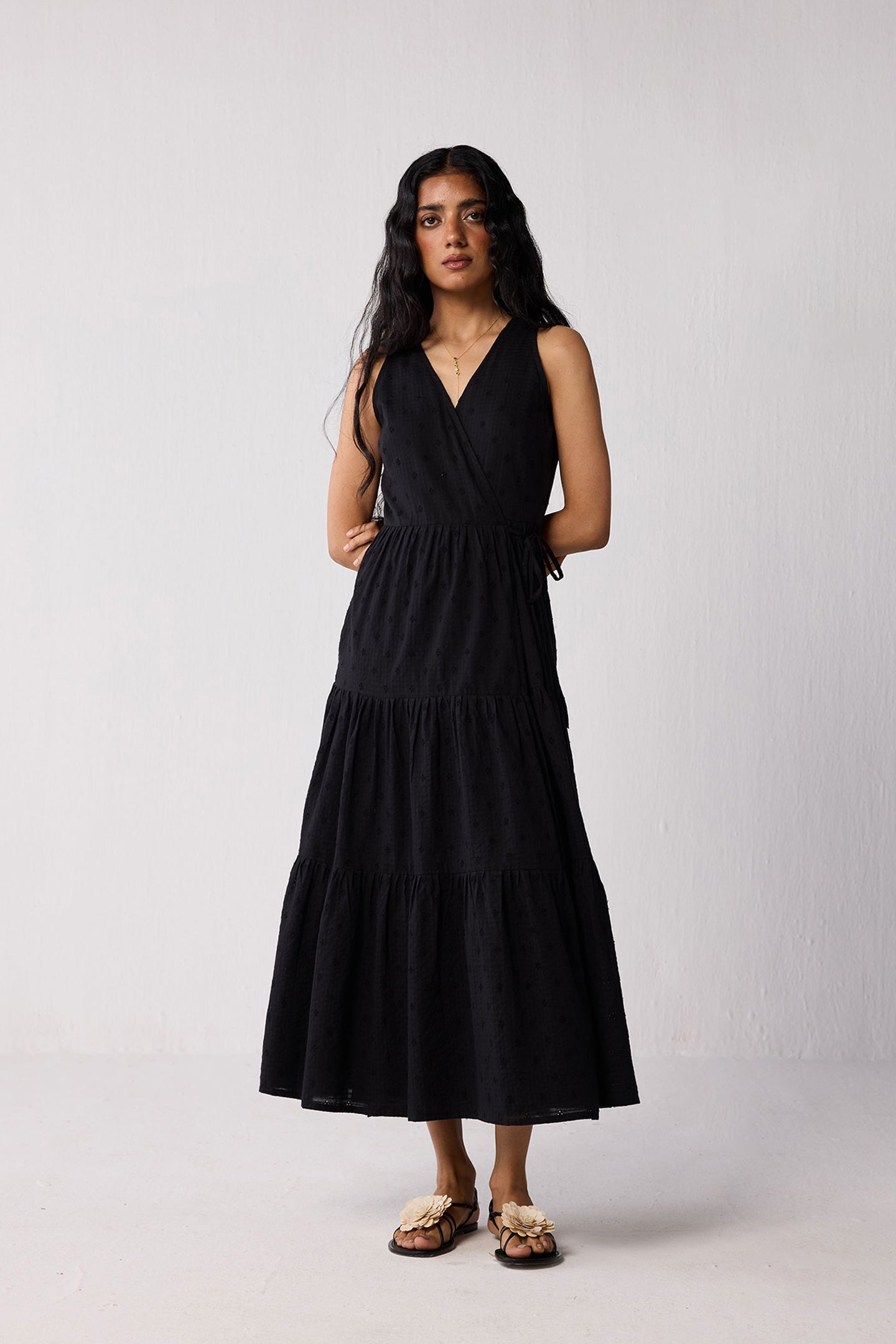 Woman wearing a black sleeveless dress against a white background