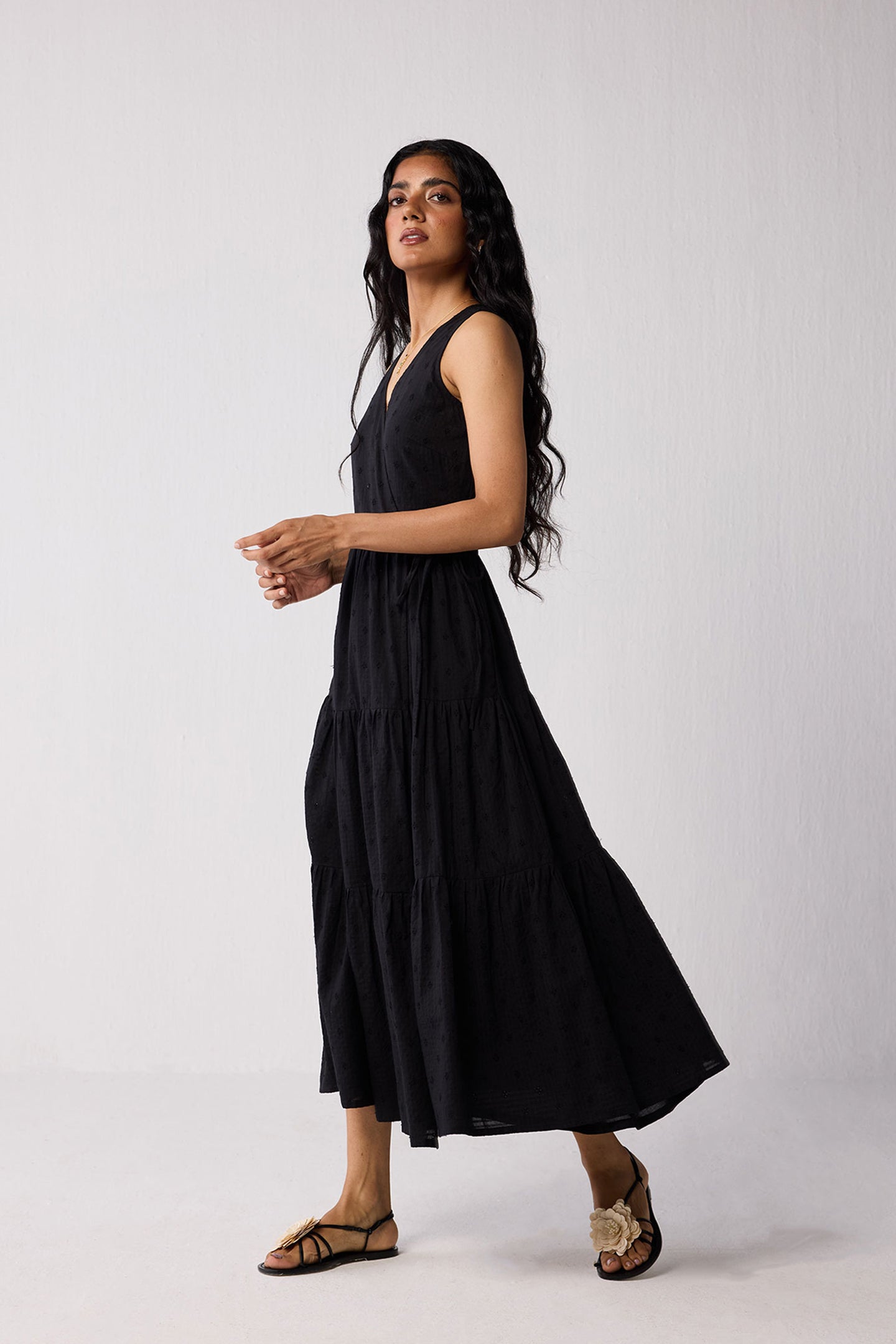 Woman wearing a black sleeveless dress against a white background