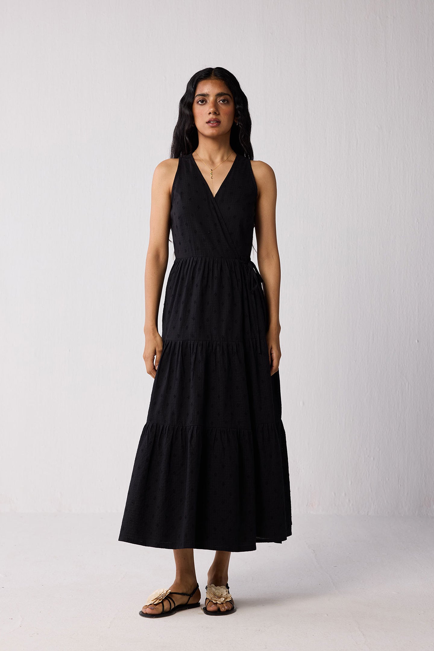 Woman wearing a black sleeveless dress against a white background