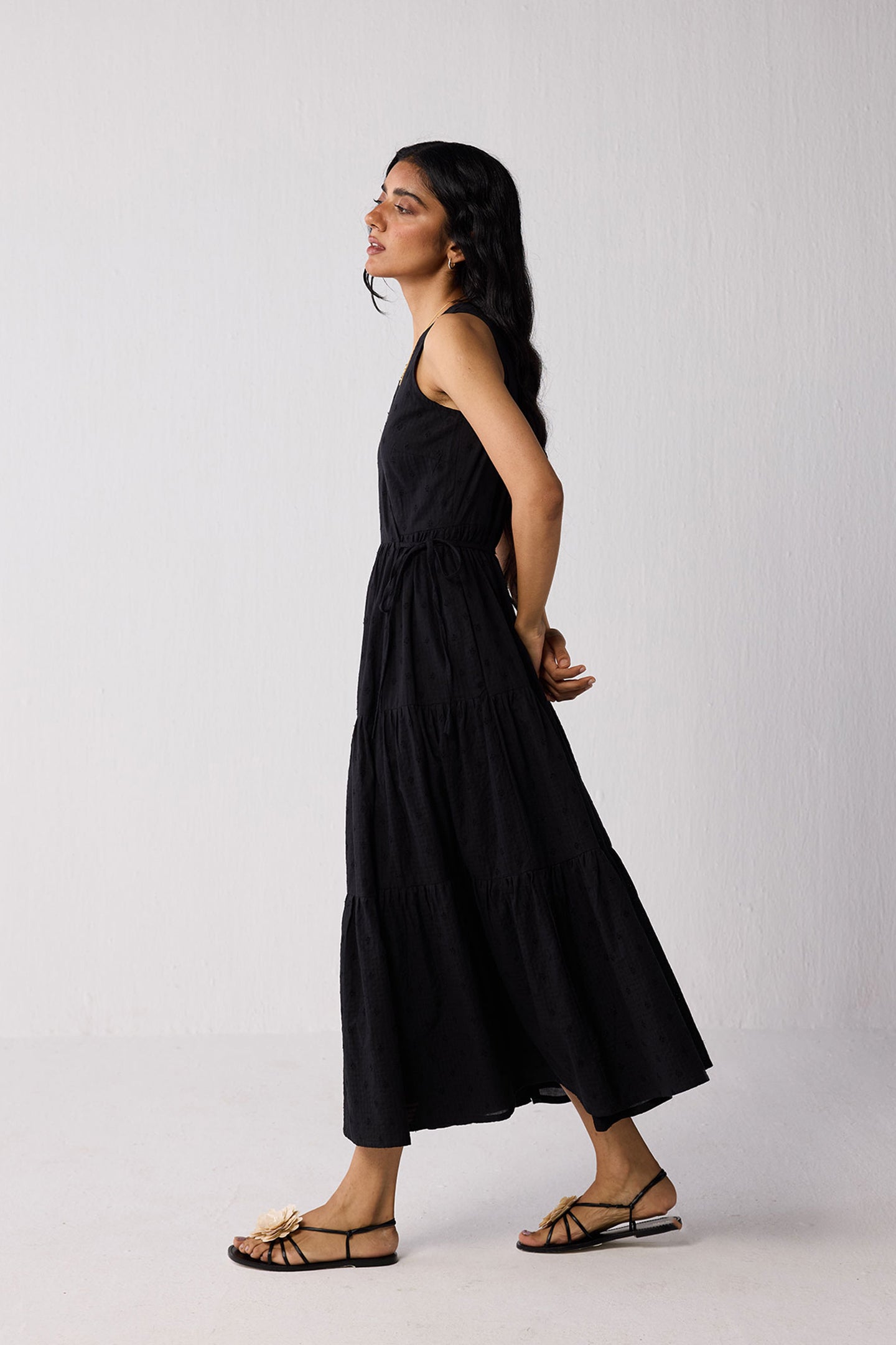Woman wearing a black sleeveless dress against a white background