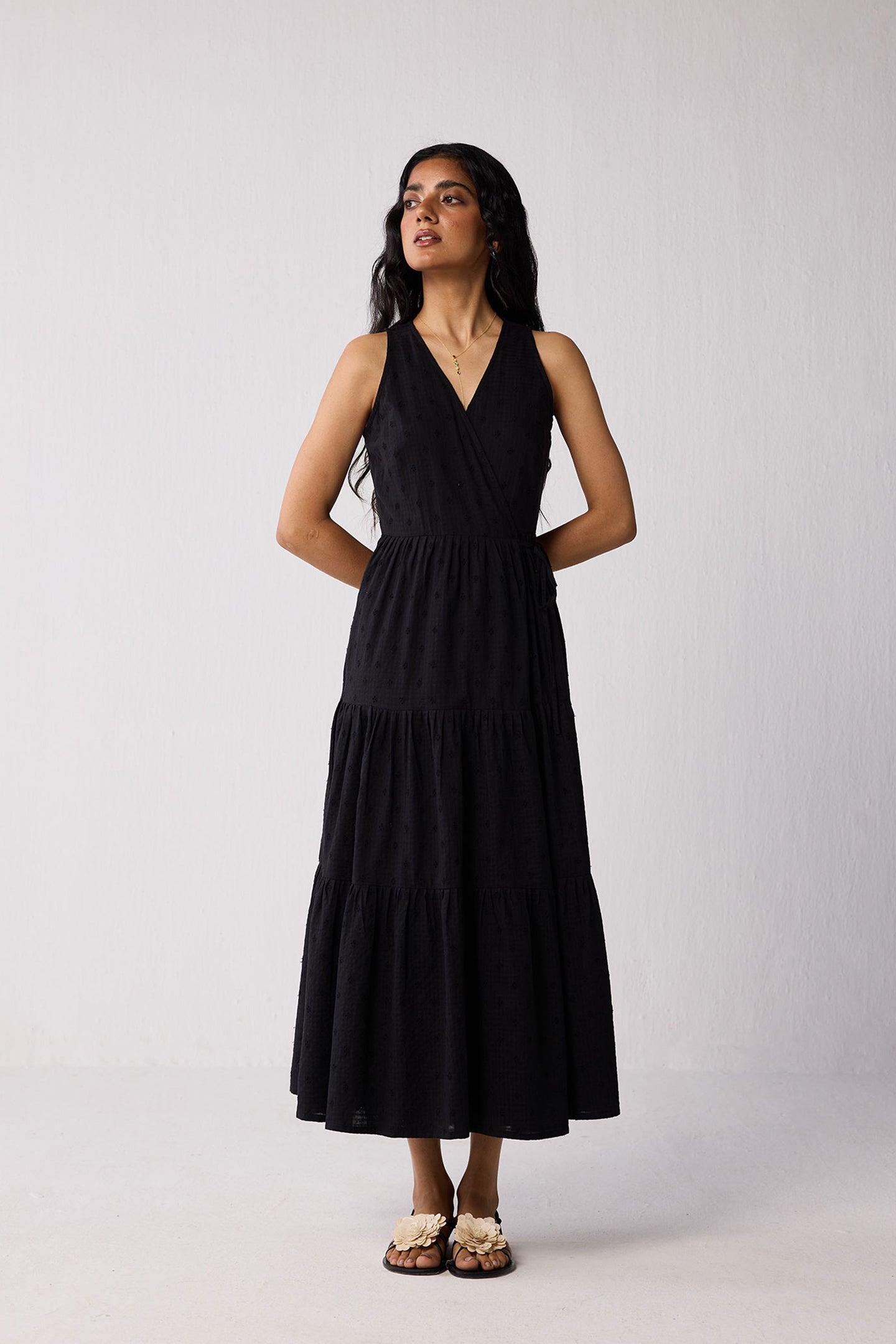 Woman wearing a black sleeveless dress against a white background