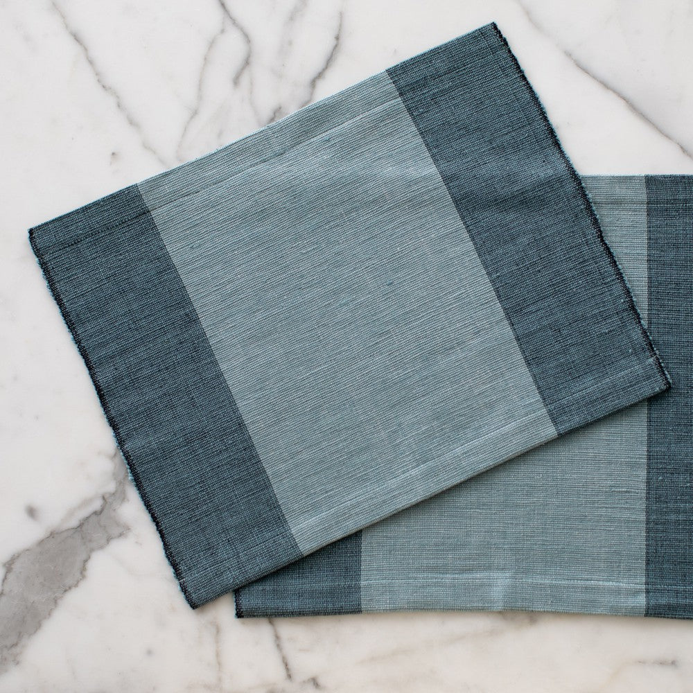 Two Sodo placemats in Flax on marble background
