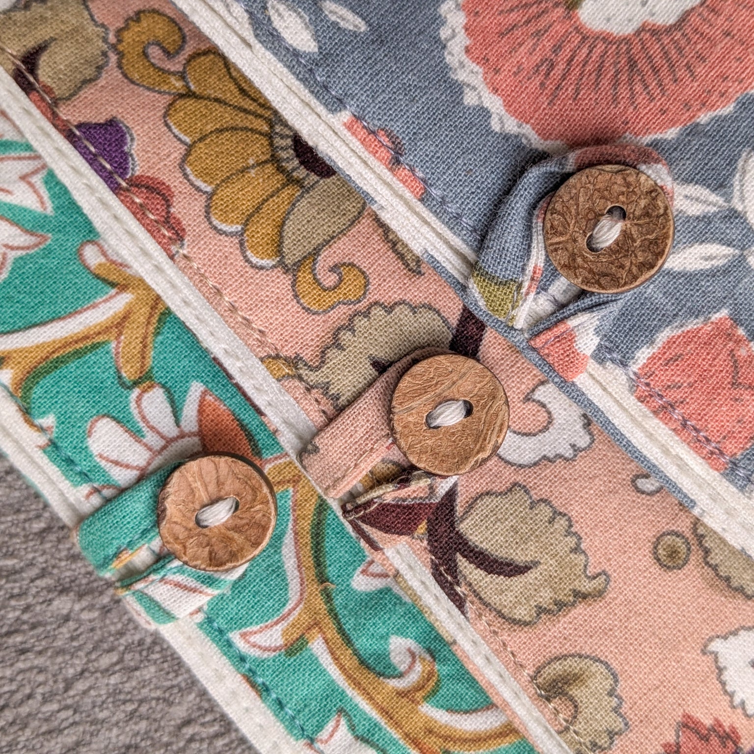 Close-up of patterned fabric with coconut shell buttons on a textured surface