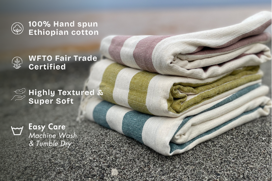 stack of folded omo towels at the beach