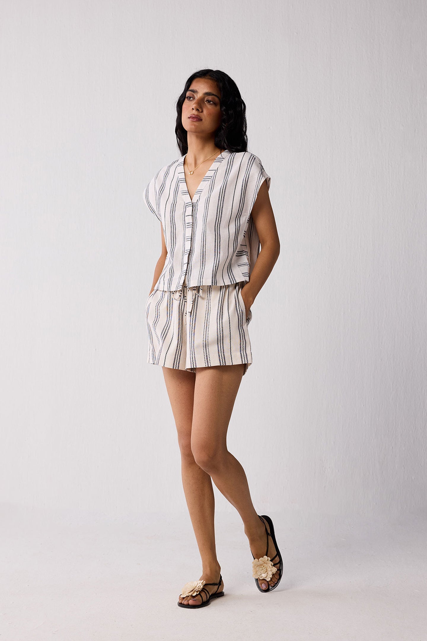 Woman wearing a striped outfit on a plain background