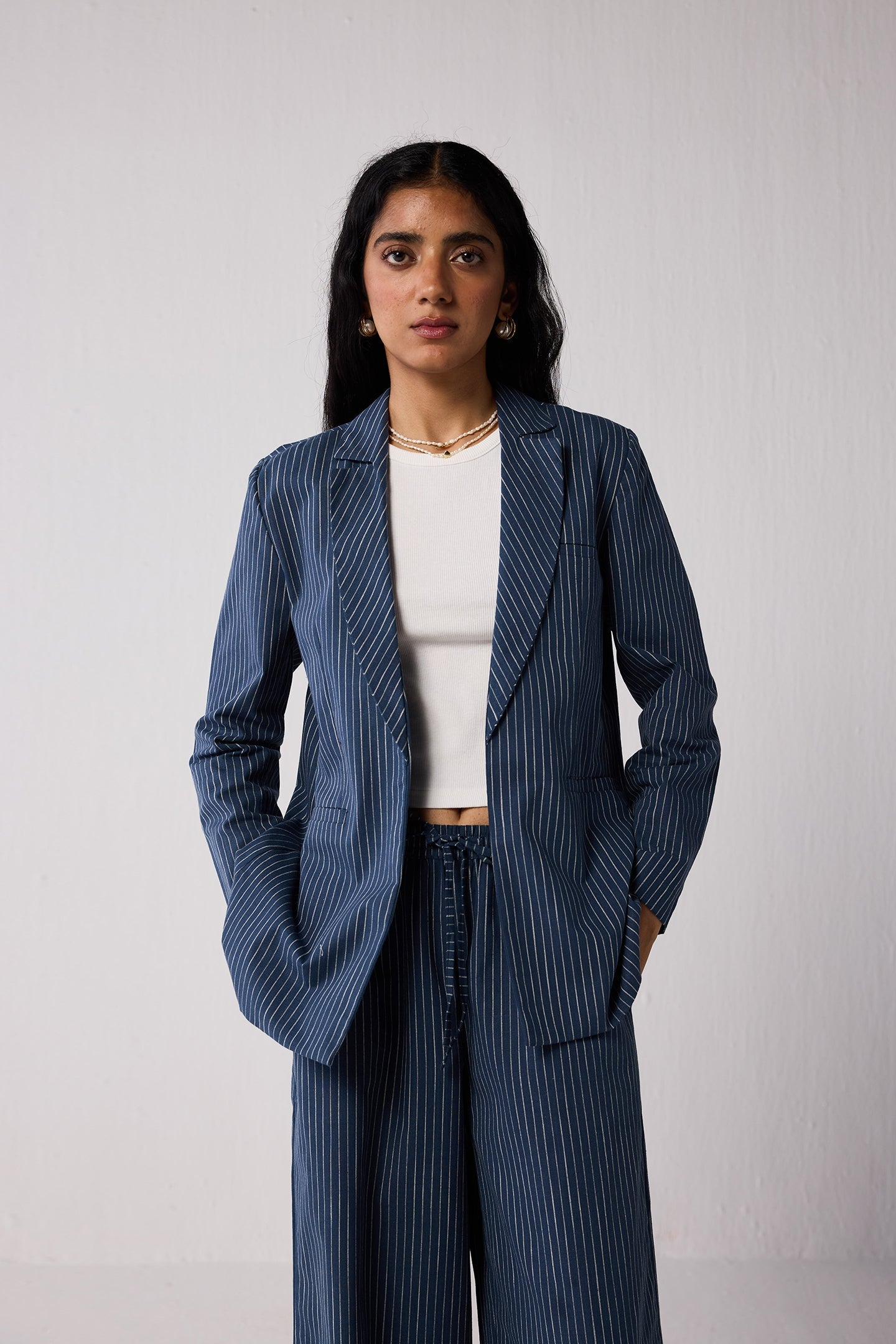 Woman wearing a blue pinstripe suit  on a light background
