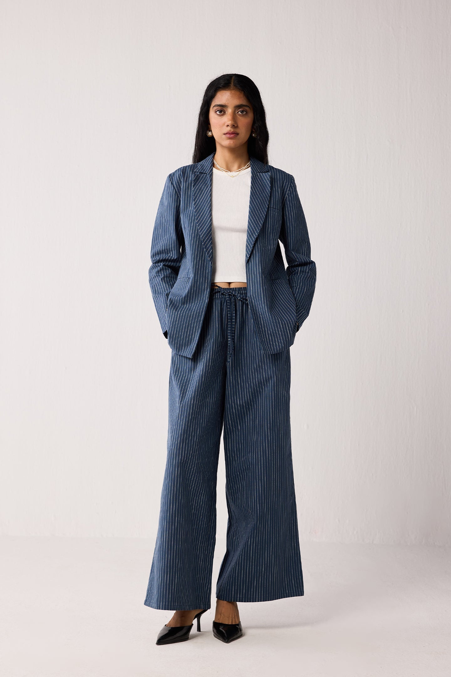 Woman wearing a blue pinstripe suit  on a light background